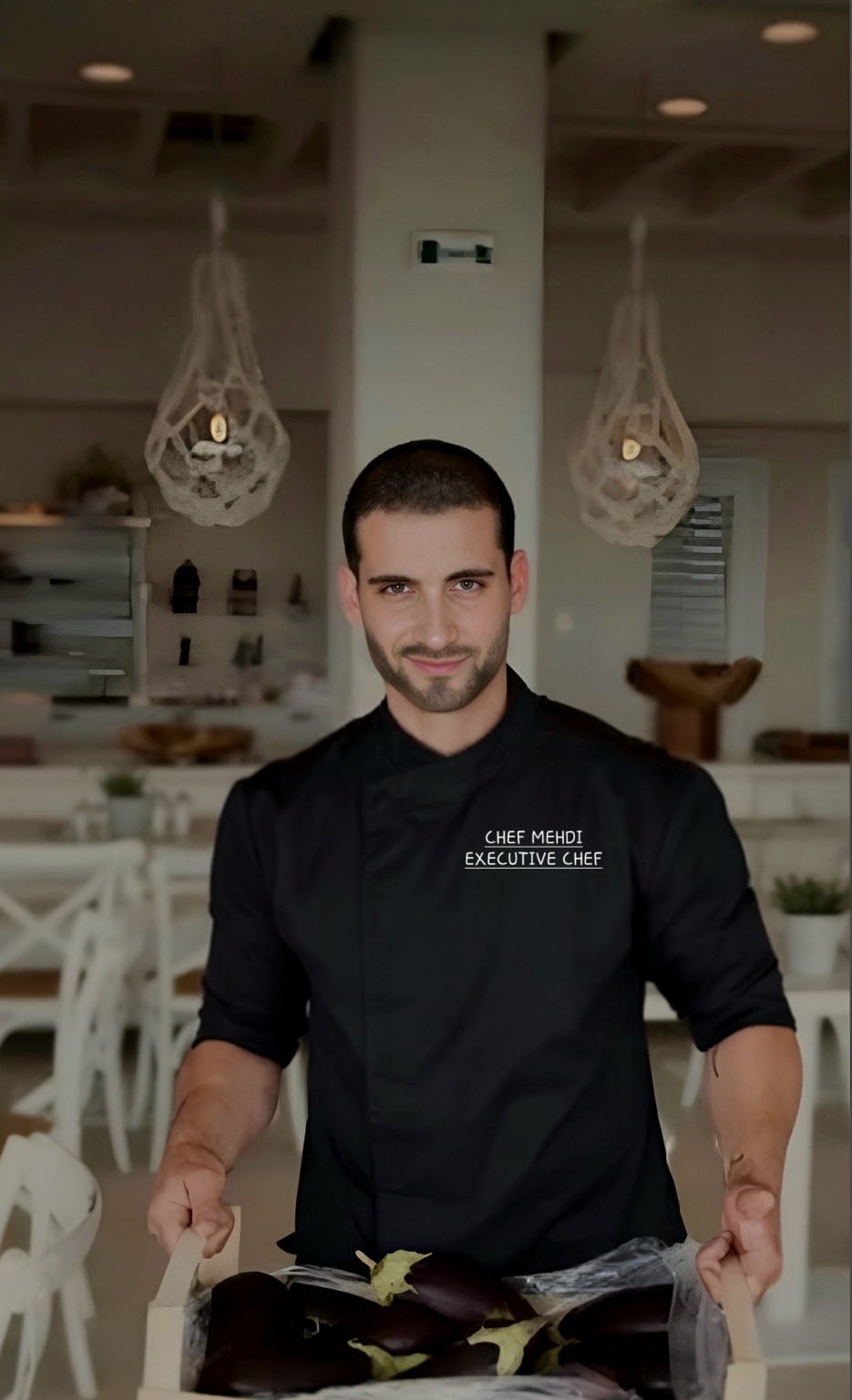 Chef Mehdi, Executive Chef, presenting fresh eggplants in a restaurant